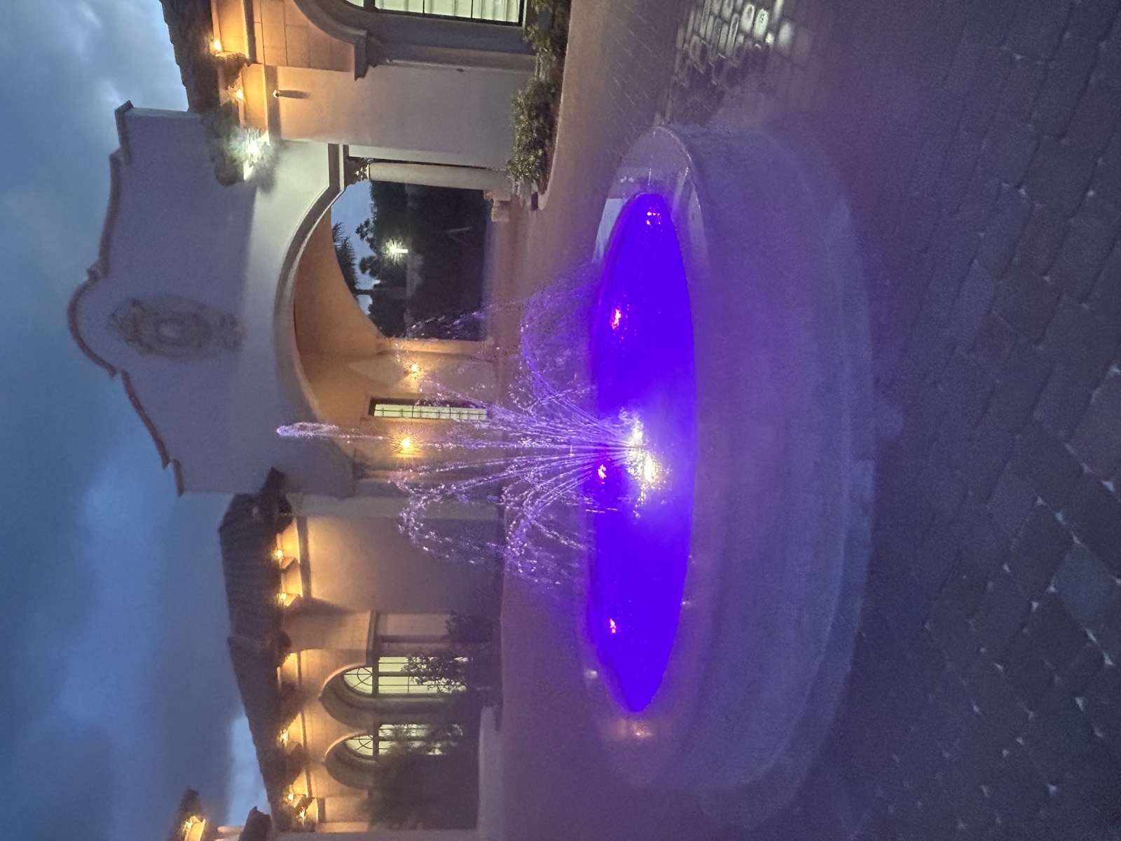 Illuminated entry fountain and warm facade lighting